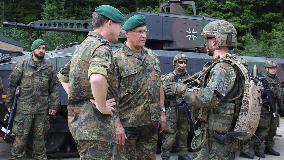 Bayerns Innenminister Joachim Herrmann (Mitte) l&auml;sst sich den tragbaren F&uuml;hrungsrechner (TFR) demonstrieren.