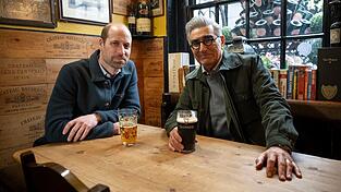 Im Pub unterhält sich Prinz William (l.) mit dem kanadischen Schauspieler Eugene Levy über Themen, die ansonsten oft tabu sind.