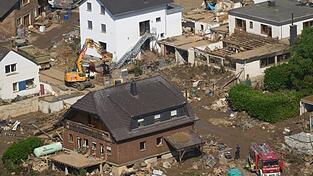 Rettungskräfte sind nach dem Hochwasser im Einsatz. Die Flut hat auch hier zahlreiche Häuser zerstört.