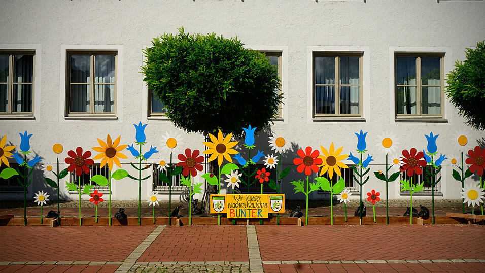 Das Titelblatt des Kalenders von Joachim Walter zeigt die heuer im Rahmen des Ferienprogramms aufgestellten farbenfrohen Holzblumen vor dem Rathaus.