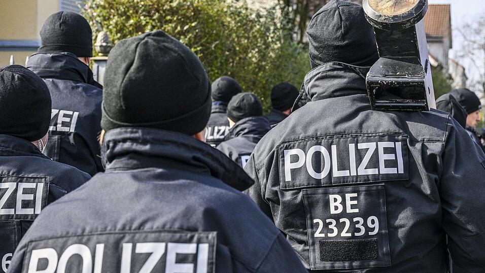 Polizisten, die eine Ramme bei sich tragen, bei einem Einsatz vor einer Villa aus dem Clan-Milieu.