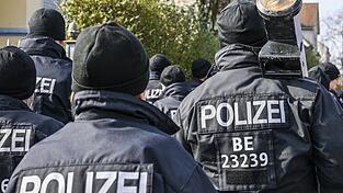 Polizisten, die eine Ramme bei sich tragen, bei einem Einsatz vor einer Villa aus dem Clan-Milieu. Polizisten, die eine Ramme bei sich tragen, bei einem Einsatz vor einer Villa aus dem Clan-Milieu.