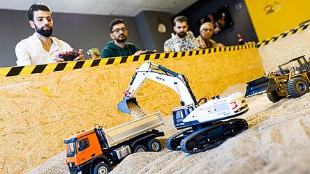 Gr&uuml;nder Siymo Othman (links) steuert mit Freunden kleine Bagger, Radlader und Lastwagen in seinem neu er&ouml;ffneten Bagger-Caf&eacute;. Es soll das erste dieser Art in Deutschland sein.