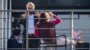 Doro Bär von der CSU wirft sich auf einer Terrasse des Jakob-Kaiser-Hauses in Positur, ihr lila Oberteil leuchtet wie eine Tulpe im hellen Licht. CDU-Chef Friedrich Merz zückt sein Handy und schießt ein Bild.