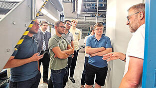 An der Rollenoffset-Druckmaschine erklärte Michael Faaß (l.) den JU-Mitglidern die Funktionsweise.