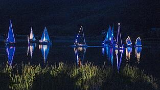 Abends bewegten sich beleuchtete Boote auf dem Wasser. Abends bewegten sich beleuchtete Boote auf dem Wasser.