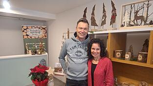 Dieter Bohatschek und seine Frau Carola vor einem Regal, bestückt mit Holz-Kunstwerken.