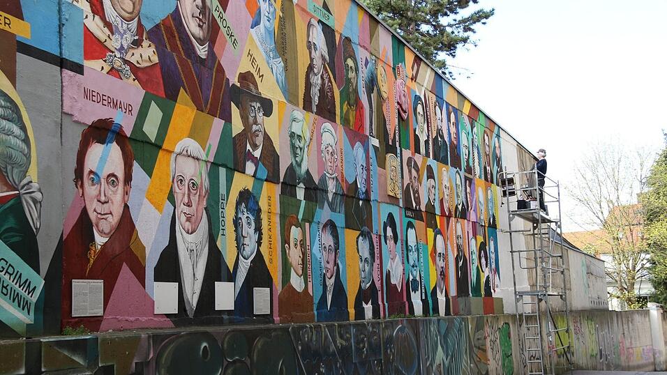 Oleg Kuzenko bei der Arbeit: 132 Regensburger Persönlichkeiten hat er auf der Mauer verewigt.