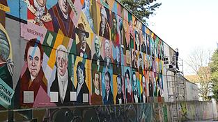 Oleg Kuzenko bei der Arbeit: 132 Regensburger Persönlichkeiten hat er auf der Mauer verewigt.