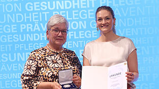 Kornelia Wedel (links) mit der Staatsmedaille f&uuml;r Verdienste um Gesundheit und Pflege, die ihr Staatsministerin Judith Gerlach &uuml;berreichte.