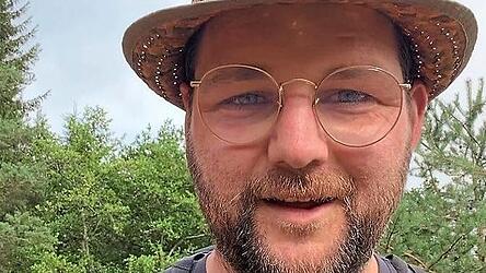 Mit Strohhut und Rucksack marschiert Johannes Becher von M&uuml;nchberg nach Moosburg.