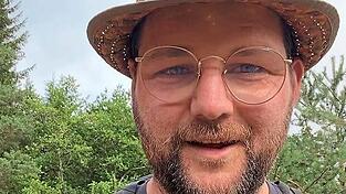 Mit Strohhut und Rucksack marschiert Johannes Becher von M&uuml;nchberg nach Moosburg.
