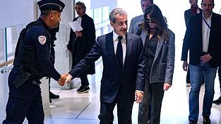 Nicolas Sarkozy (M.) kommt mit seiner Frau Carla Bruni zum letzten Tag seines Prozesses. Die Anklage fordert sieben Jahre Haft.