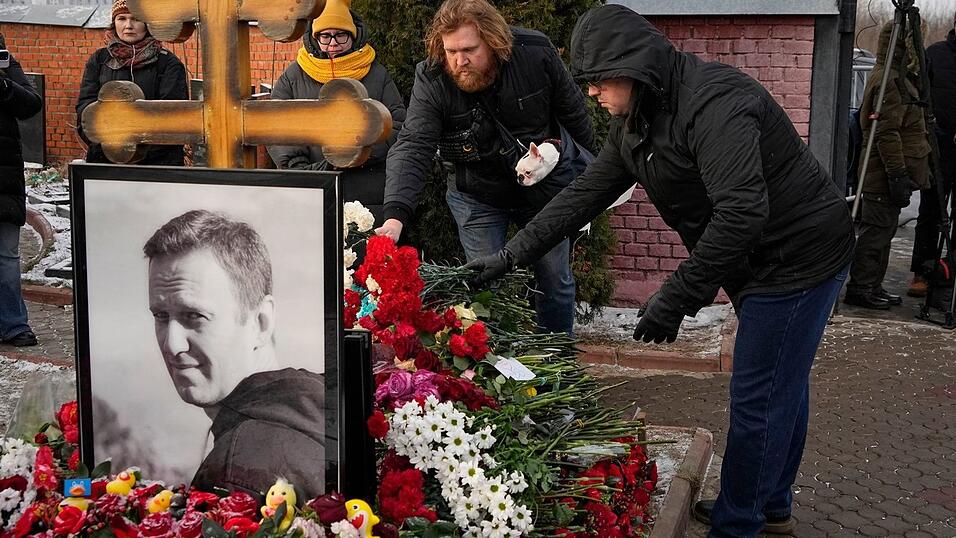 Menschen legen ein Jahr nach dem Tod des russischen Oppositionsf&uuml;hrers Alexej Nawalny auf dem Borisowskoje-Friedhof in Moskau Blumen an seinem Grab nieder.