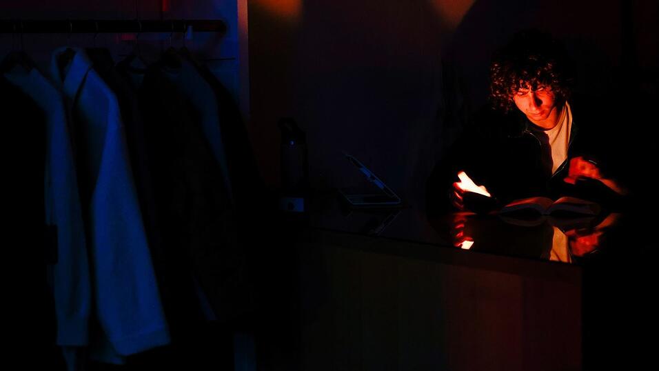 Ein Mann liest w&auml;hrend des Stromausfalls in San Francisco bei Kerzenlicht.