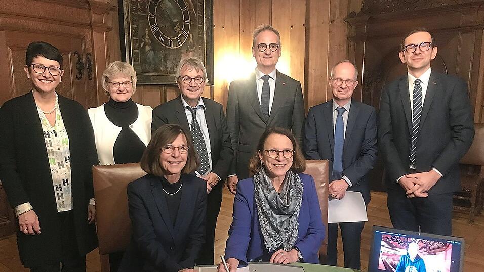 Oberbürgermeisterin Gertrud Maltz-Schwarzfischer (vorne rechts) und Uni-Vizepräsidentin Ursula Regener (vorne links) bei der Vertragsunterzeichnung.