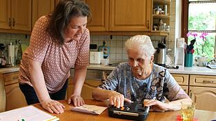 Ruth Nolte (links) erklärt Krista Hehberger, wie sie mit einem Gerät Hörbücher abspielen kann. Ruth Nolte (links) erklärt Krista Hehberger, wie sie mit einem Gerät Hörbücher abspielen kann.