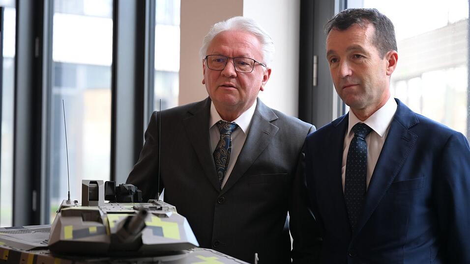 Papperger und Escribano bei einem Modell des Rheinmetall-Kampfpanzers Panther.