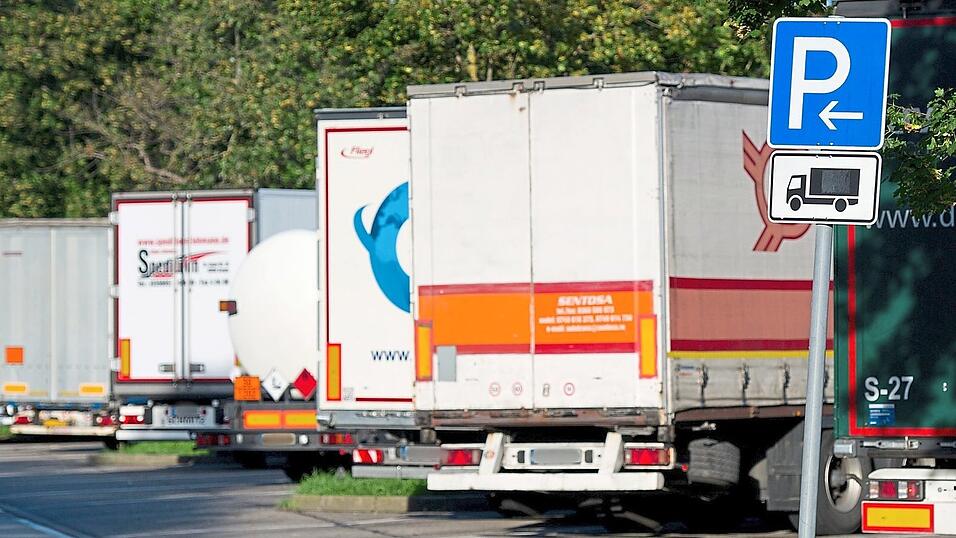Geparkte Lastwagen stehen auf einem Autobahnrastplatz. „Planenschlitzer“ erkunden durch Schlitze in der Plane die Ladung, bevor sie zuschlagen. Geparkte Lastwagen stehen auf einem Autobahnrastplatz. „Planenschlitzer“ erkunden durch Schlitze in der Plane die Ladung, bevor sie zuschlagen.
