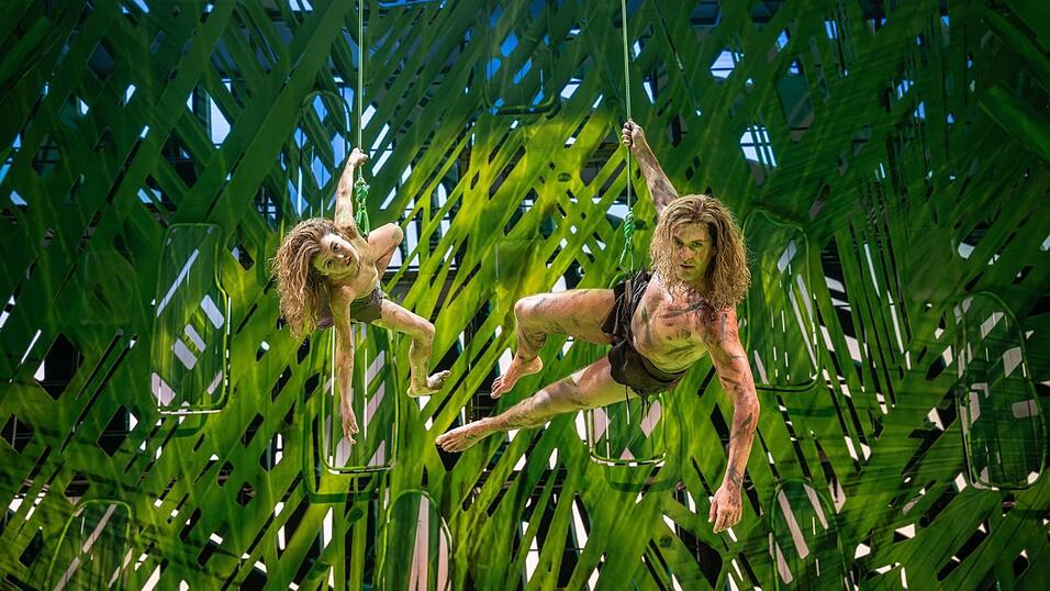 Vater und Sohn schwingen sich an Lianen durch den Dschungel. Vater und Sohn schwingen sich an Lianen durch den Dschungel.