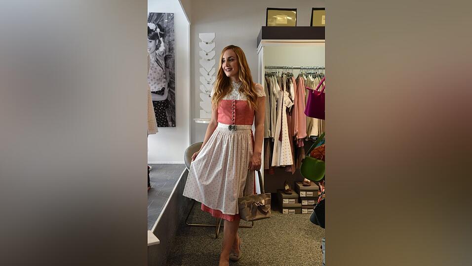 Auch dieses Dirndl trägt man am besten mit einer hochgeschlossenen Bluse. Die passenden Schuhe und eine Tasche runden den Look ab.