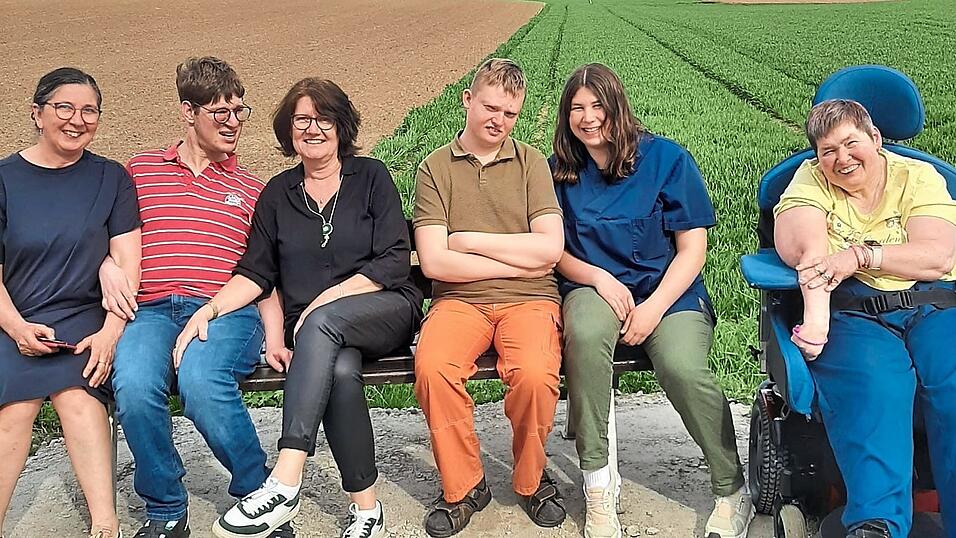Schon 'eingeweiht' haben auch die Bewohner des Lebenshilfe-Wohnheims das neue Bankerl. Bettina Wiese (l.) und Veronika Maidl (2.v.l.) freuen sich, dass ihre Bitte so schnell erf&uuml;llt wurde.