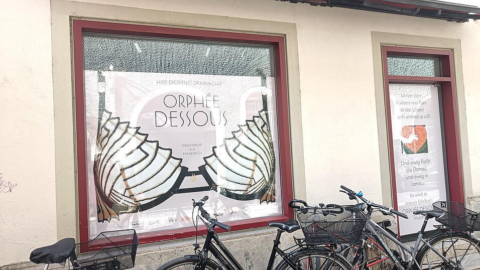 Passanten wundern sich in der Unteren Bachgasse &uuml;ber den riesigen BH im Orph&eacute;e-Schaufenster.