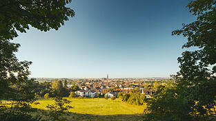 Blick auf Regensburg mit Grünflächen im Vordergrund. Eine OTH-Bachelorarbeit und der Regensburger Armutsbericht zeigen, dass Menschen in sozial benachteiligten Stadtquartieren häufig stärker von Hitze betroffen sind und schlechteren Zugang zu kühlenden Aufenthaltsorten haben. Blick auf Regensburg mit Grünflächen im Vordergrund. Eine OTH-Bachelorarbeit und der Regensburger Armutsbericht zeigen, dass Menschen in sozial benachteiligten Stadtquartieren häufig stärker von Hitze betroffen sind und schlechteren Zugang zu kühlenden Aufenthaltsorten haben.