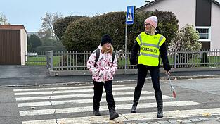 Mit netten Worten begleitet die Schulweghelferin Lilly &uuml;ber die Stra&szlig;e.