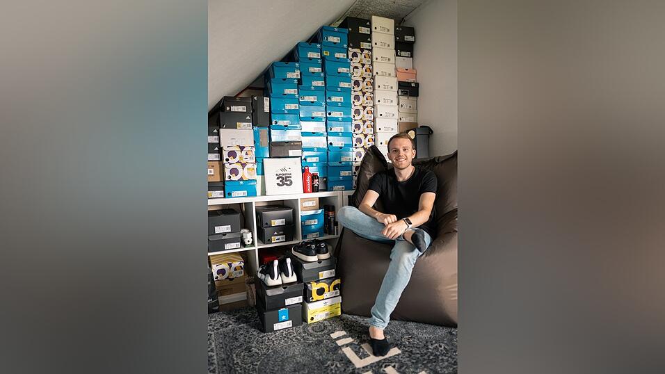 Tobi vor einer riesigen Schuhkarton-Wand.