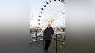 Der Dirigent Simon Rattle auf dem Dach des Werk 3 im Werksviertel, hinter ihm das Riesenrad. Es steht auf dem Bauplatz für das vom Freistaat geplante, derzeit aber gefährdete Konzerthaus für das Symphonieorchester des Bayerischen Rundfunks.