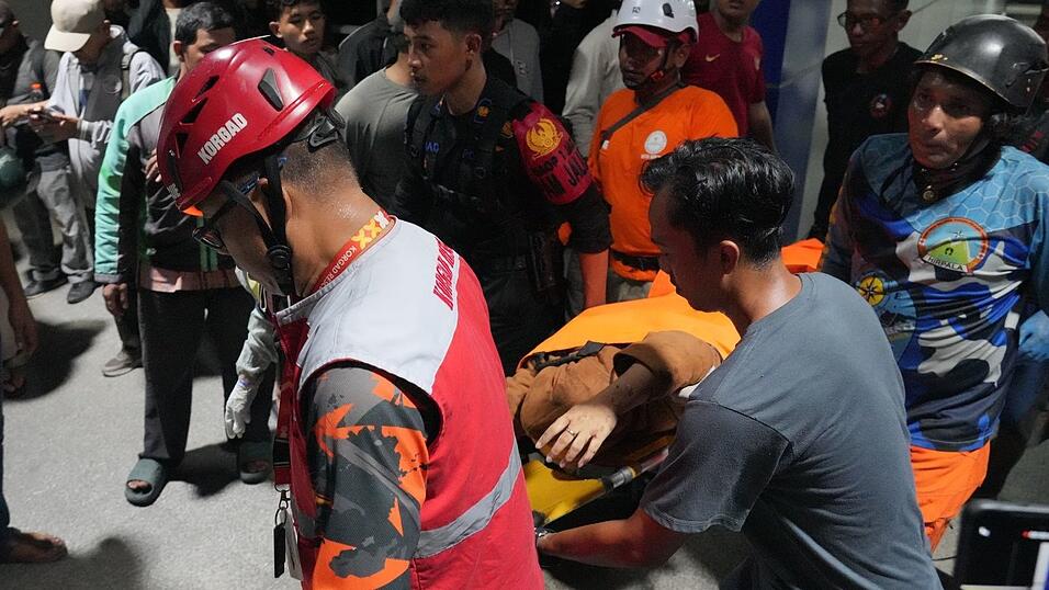 Retter tragen eine Frau auf einer Trage.