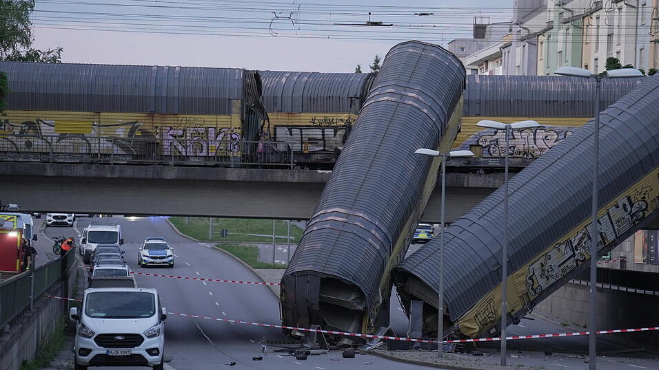 Zwei Waggons eines G&uuml;terzugs liegen auf der Stra&szlig;e, nachdem sie von einer Br&uuml;cke gest&uuml;rzt sind.
