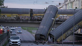 Zwei Waggons eines Güterzugs liegen auf der Straße, nachdem sie von einer Brücke gestürzt sind. Zwei Waggons eines Güterzugs liegen auf der Straße, nachdem sie von einer Brücke gestürzt sind.