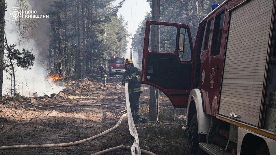Ukrainische Feuerwehrleute l&ouml;schen einen durch russischen Beschuss ausgel&ouml;sten Waldbrand..