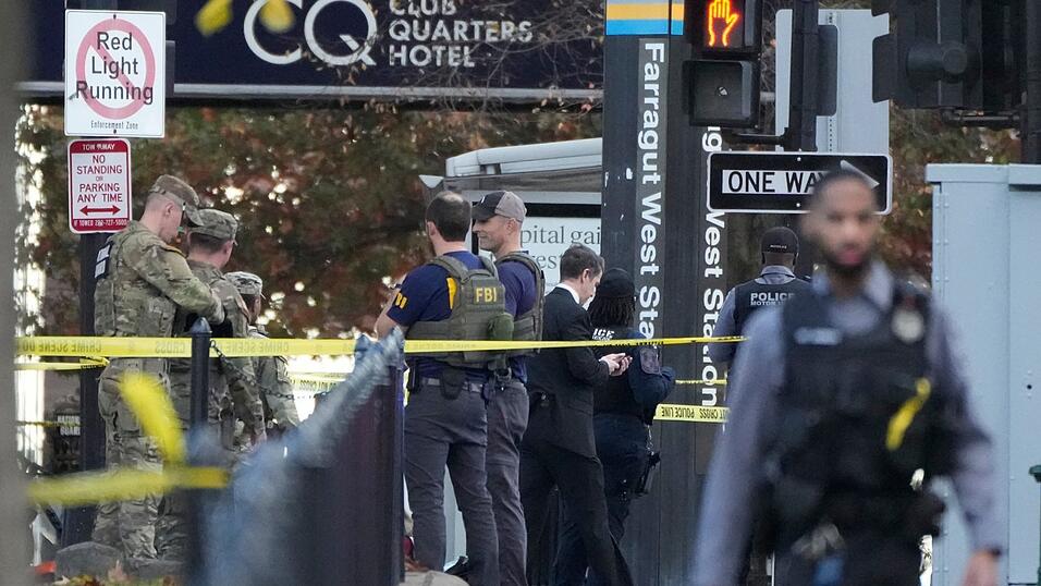 Soldaten und Mitglieder des FBI sind im Einsatz, nachdem zwei Mitglieder der Nationalgarde von Schüssen getroffen wurden. Soldaten und Mitglieder des FBI sind im Einsatz, nachdem zwei Mitglieder der Nationalgarde von Schüssen getroffen wurden.