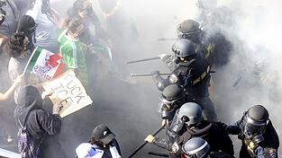 Rauch liegt in der Luft, als Demonstranten sich mit CHP-Beamten anlegen, nachdem sie den 101 Freeway in der Innenstadt besetzt haben, um gegen die Durchsuchung von Einwanderern zu protestieren.