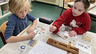 Diese Kinder versuchen gerade, ägyptische Schriftzeichen mit einer Binse und Tinte nachzumalen. Diese Kinder versuchen gerade, ägyptische Schriftzeichen mit einer Binse und Tinte nachzumalen.