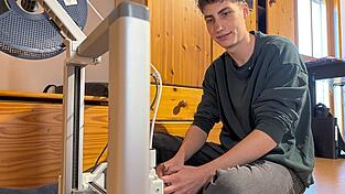 Benjamin Walch verfolgt die Arbeit seines 3D-Druckers. Das Ger&auml;t surrt, rattert und spuckt schwarze Kunststoffteile aus.