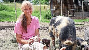 Marianne Wiesheu mit ihren borstigen Lieblingen: Ihre Kunekune-Schweine h&auml;lt sie in ihrem Freigehege - sogar Eber &bdquo;Kalle&ldquo; bleibt absolut friedlich, wenn sich Menschen seinem Nachwuchs n&auml;hern.