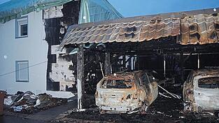Die Fahrzeuge im Carport v&ouml;llig ausgebrannt, die Fassade verru&szlig;t, das Dach teilweise offen und behelfsm&auml;&szlig;ig mit einer riesigen Plane abgedeckt: So sieht es zehn Tage nach dem Brand an der M&uuml;hlbogenstra&szlig;e aus.