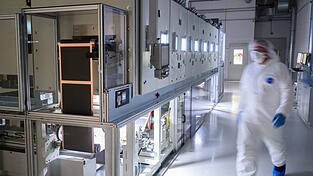 Mitarbeiter stehen in einer Pilotanlage zur Batteriezellenproduktion.