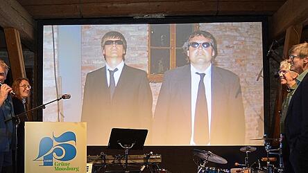 Mit „Dalli Klick“ wurde auf die „Men in Black“ Dr. Michael Stanglmaier und Anton Wollschläger bei der 25-Jahr-Feier der Grünen Moosburg geschaut.