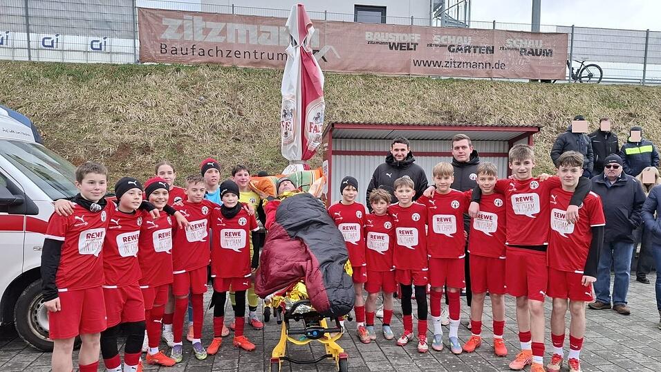 Eine Aktion, die so nicht geplant war und sich in der Halbzeitpause spontan ergab: Zusammen mit ihren Trainern Johannes Standecker (hinten rechts) und Michael Lamecker (hinten links) begleiteten Elias&rsquo; Mannschaftskameraden ihren Teamkollegen f&uuml;r ein Gruppenbild geschlossen zu seinem Vater.