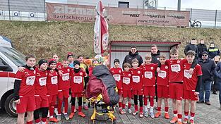 Eine Aktion, die so nicht geplant war und sich in der Halbzeitpause spontan ergab: Zusammen mit ihren Trainern Johannes Standecker (hinten rechts) und Michael Lamecker (hinten links) begleiteten Elias’ Mannschaftskameraden ihren Teamkollegen für ein Gruppenbild geschlossen zu seinem Vater. Eine Aktion, die so nicht geplant war und sich in der Halbzeitpause spontan ergab: Zusammen mit ihren Trainern Johannes Standecker (hinten rechts) und Michael Lamecker (hinten links) begleiteten Elias’ Mannschaftskameraden ihren Teamkollegen für ein Gruppenbild geschlossen zu seinem Vater.