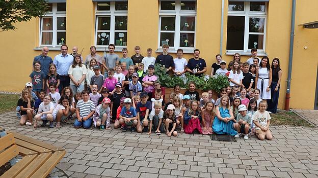 Die Untertraubenbacher Grundsch&uuml;ler mit Schulleiterin Kerstin Bauer, die acht RSG-Sch&uuml;ler mit ihrem Lehrer Robert St&ouml;gbauer und Schulleiter Rudolf Zell sowie Vertreter der Stadt vor den neuen Hochbeeten.