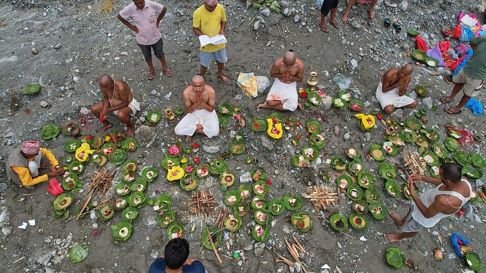 Menschen, deren Angeh&ouml;rige nach den Sturzfluten weiterhin vermisst werden, vollziehen am Ufer des angeschwollenen Trishuli-Flusses im nepalesischen Distrikt Nuwakot Rituale im Anschluss an symbolische Bestattungszeremonien.
