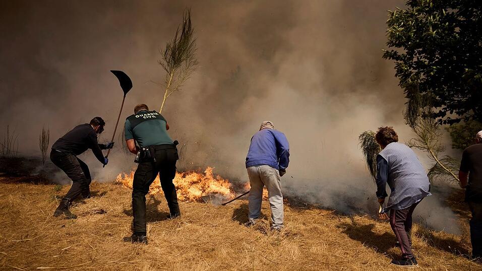 Unermüdlich kämpfen Einsatzkräfte und freiwillige Helfer gegen die Flammen.