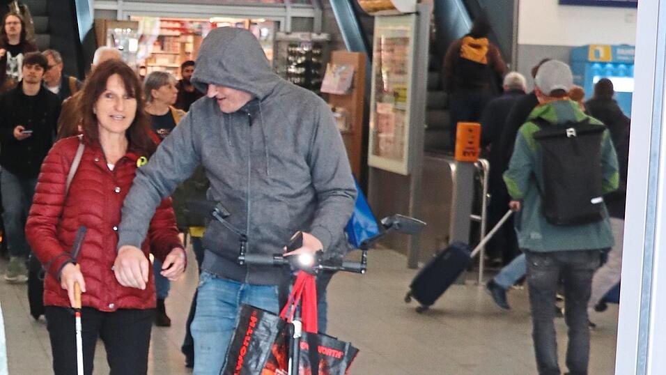 Beherzt nimmt der Mann mit E-Scooter und grauer Sweatshirt-Jacke Hannelore Winbeck an die Hand und führt sie zum Bahnhofsausgang. Beherzt nimmt der Mann mit E-Scooter und grauer Sweatshirt-Jacke Hannelore Winbeck an die Hand und führt sie zum Bahnhofsausgang.