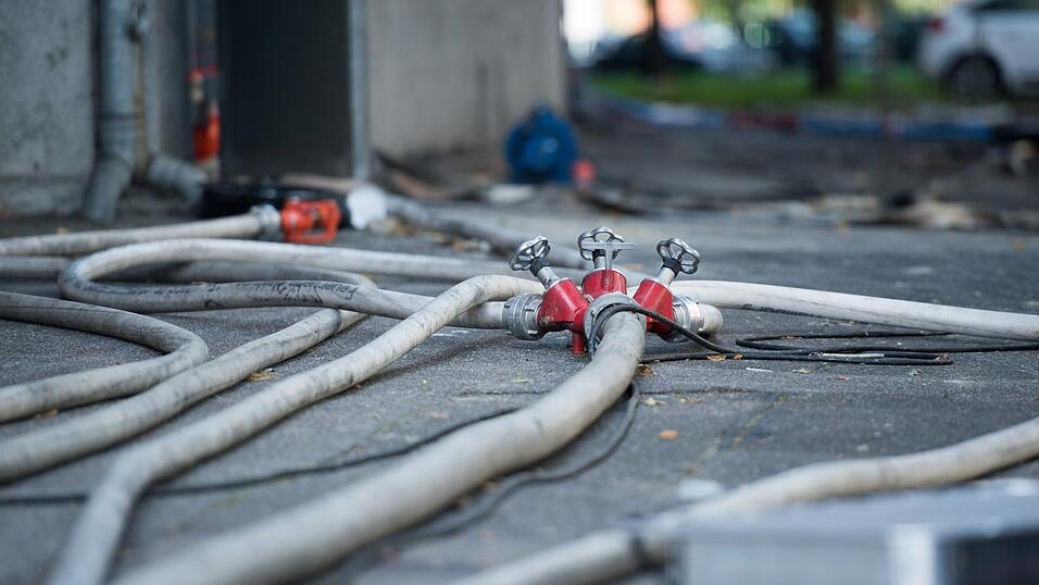 Feuerwehrleute l&ouml;schten die brennenden Ger&auml;te drau&szlig;en im Garten.